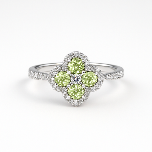 Silver Ring with green peridot gemstones in a clover design and moissanite pave stone on the band. The ring sits on a white background